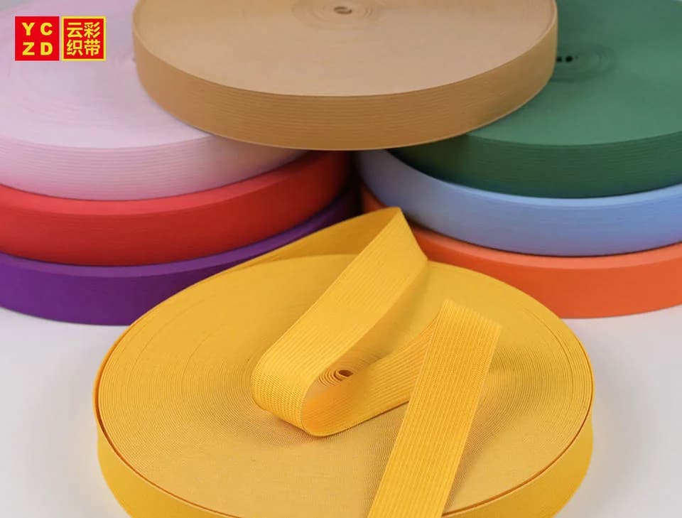 Yellow elastic tape in front of stacked colourful rolls