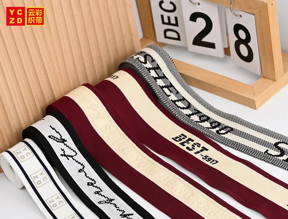 Burgundy, cream and black jacquard tapes with contrasting letters