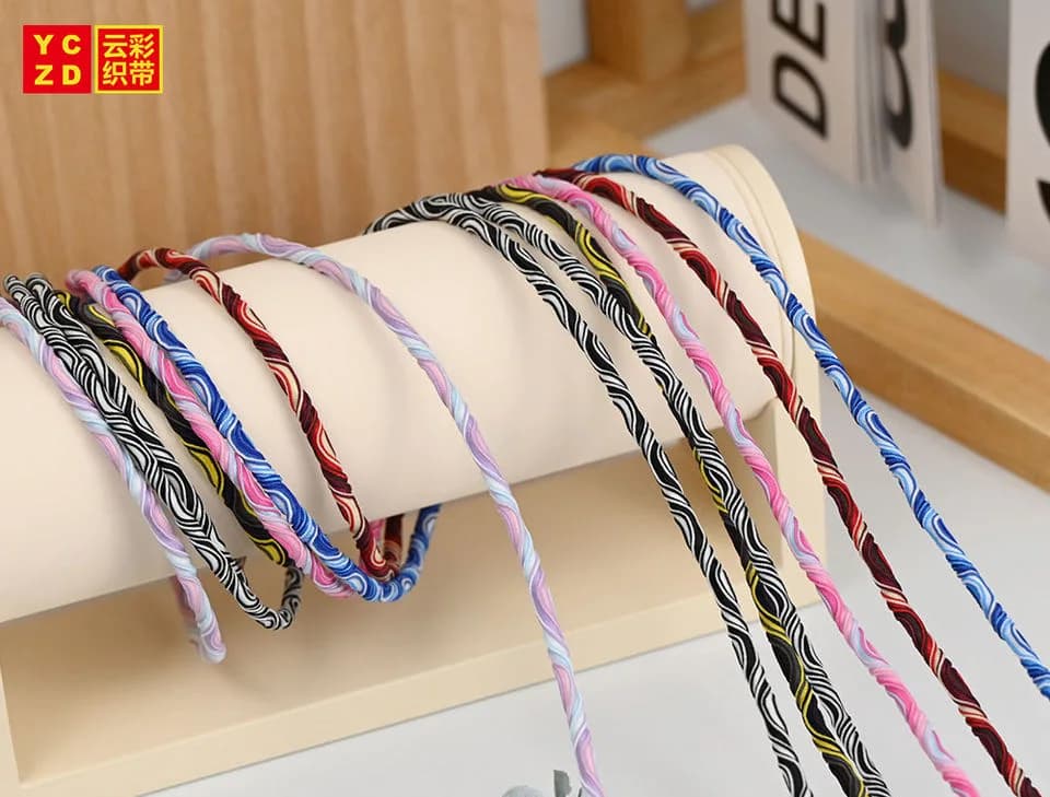 Multicoloured patterned cords hanging over a white display bar