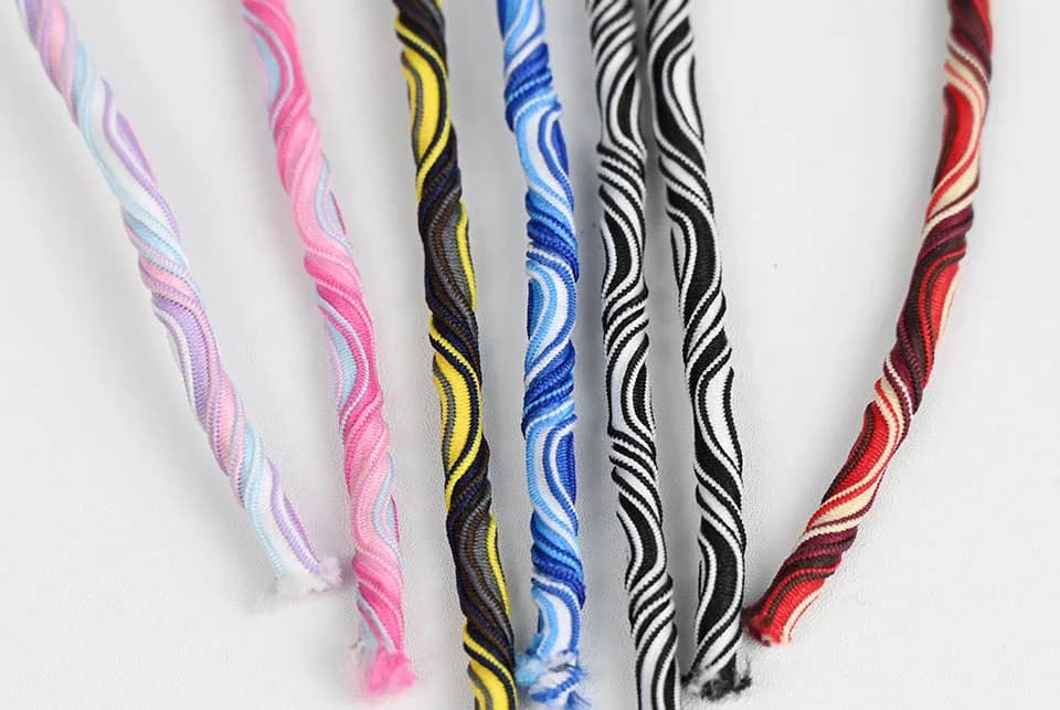 Pink, yellow, blue and black striped cords hanging vertically
