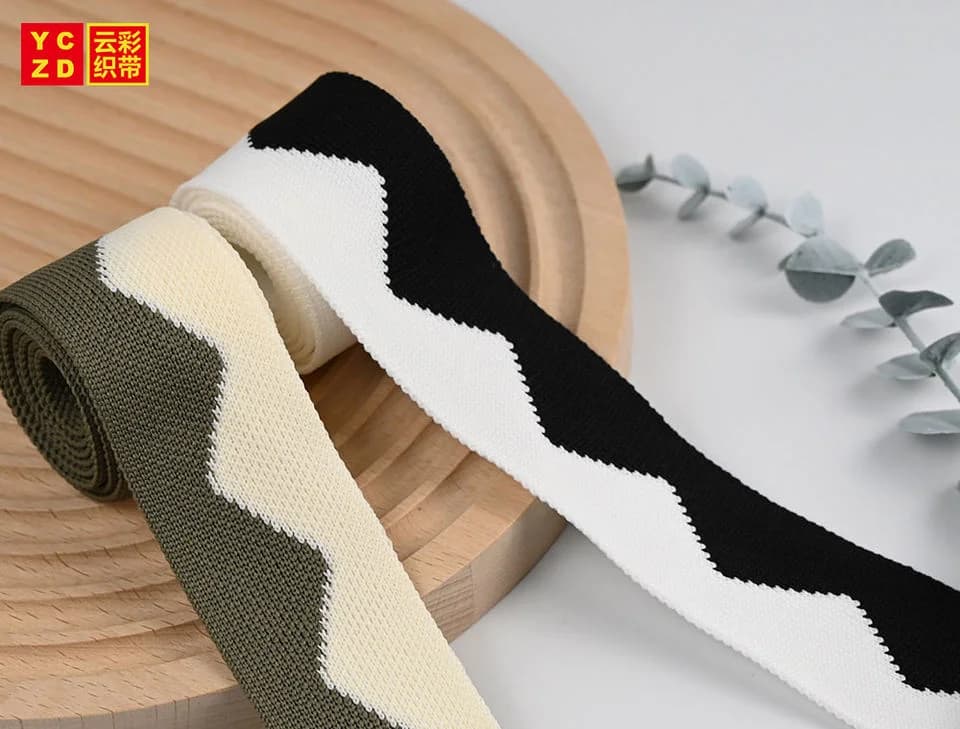 Plain olive, cream and black tapes curled on a grey surface