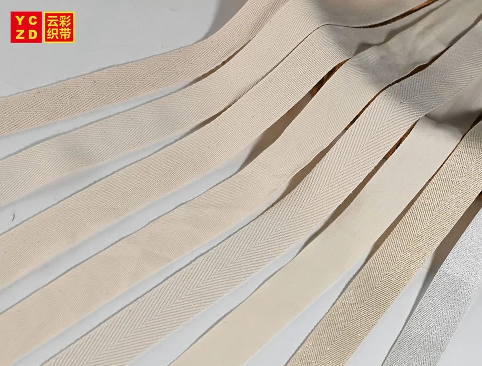 Cream woven tapes laid diagonally across a grey surface