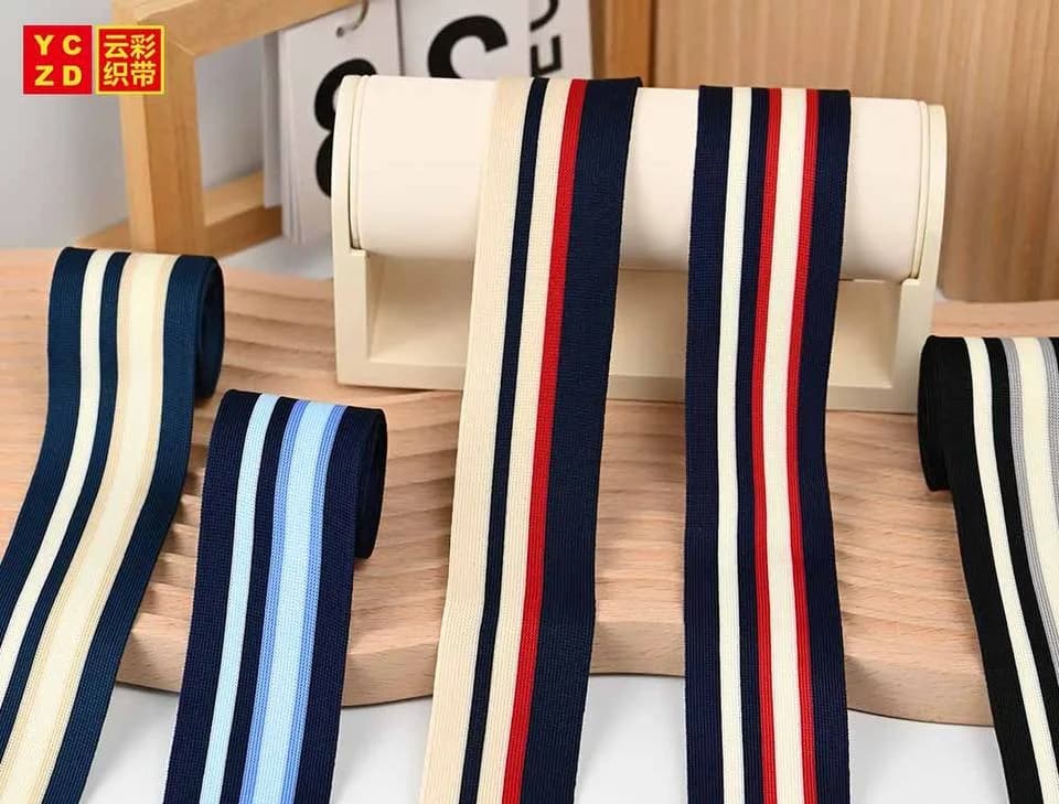 Cream tapes with red and navy stripes hanging from a display bar