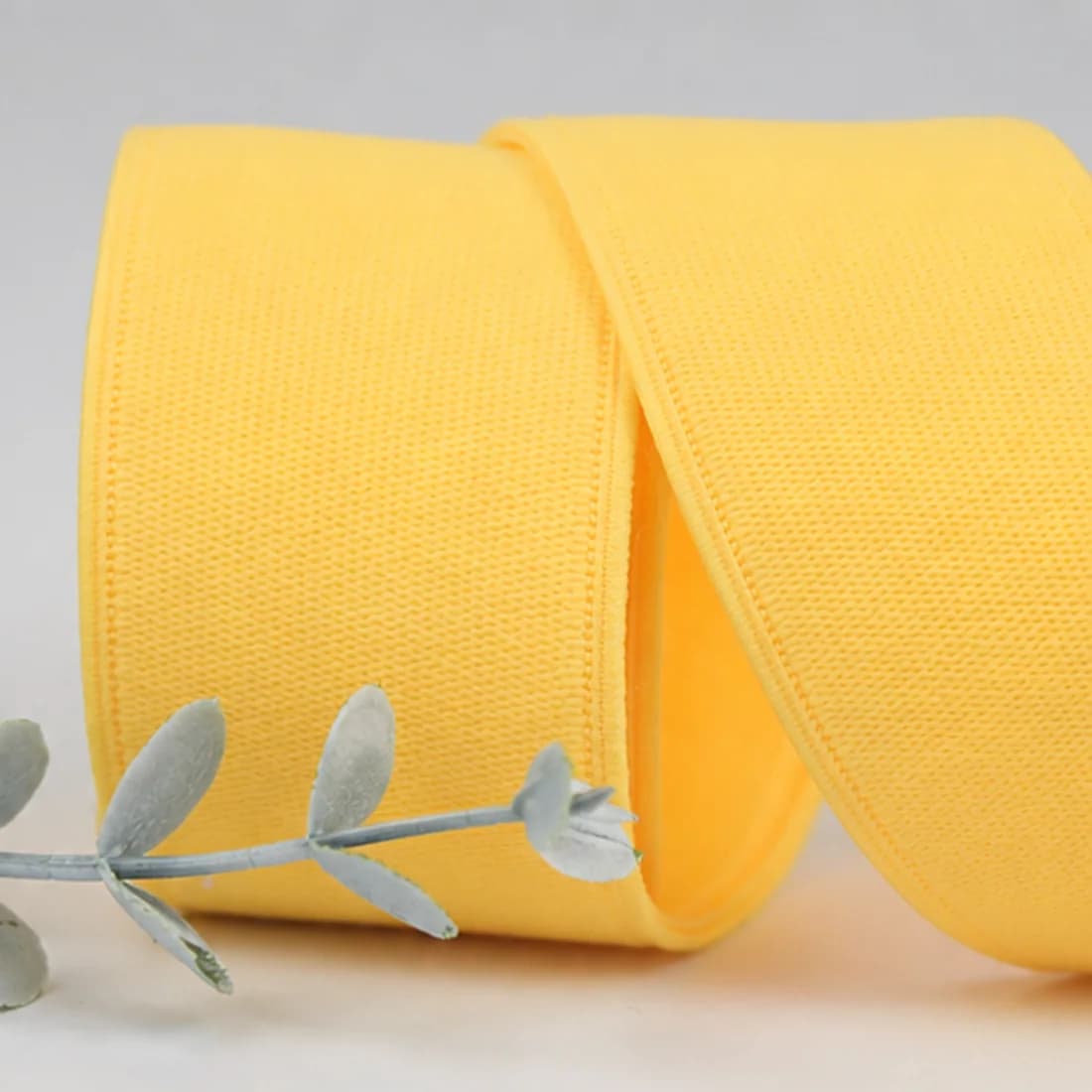 Close view of a real yellow garment elastic showing knit texture and edge construction