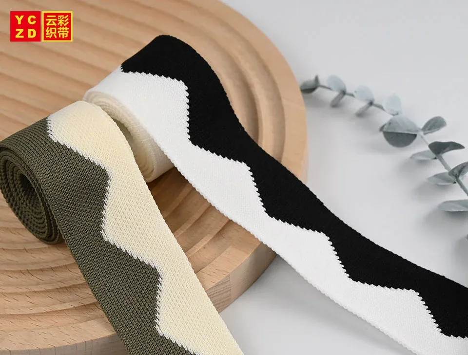 Plain olive, cream and black tapes curled on a grey surface