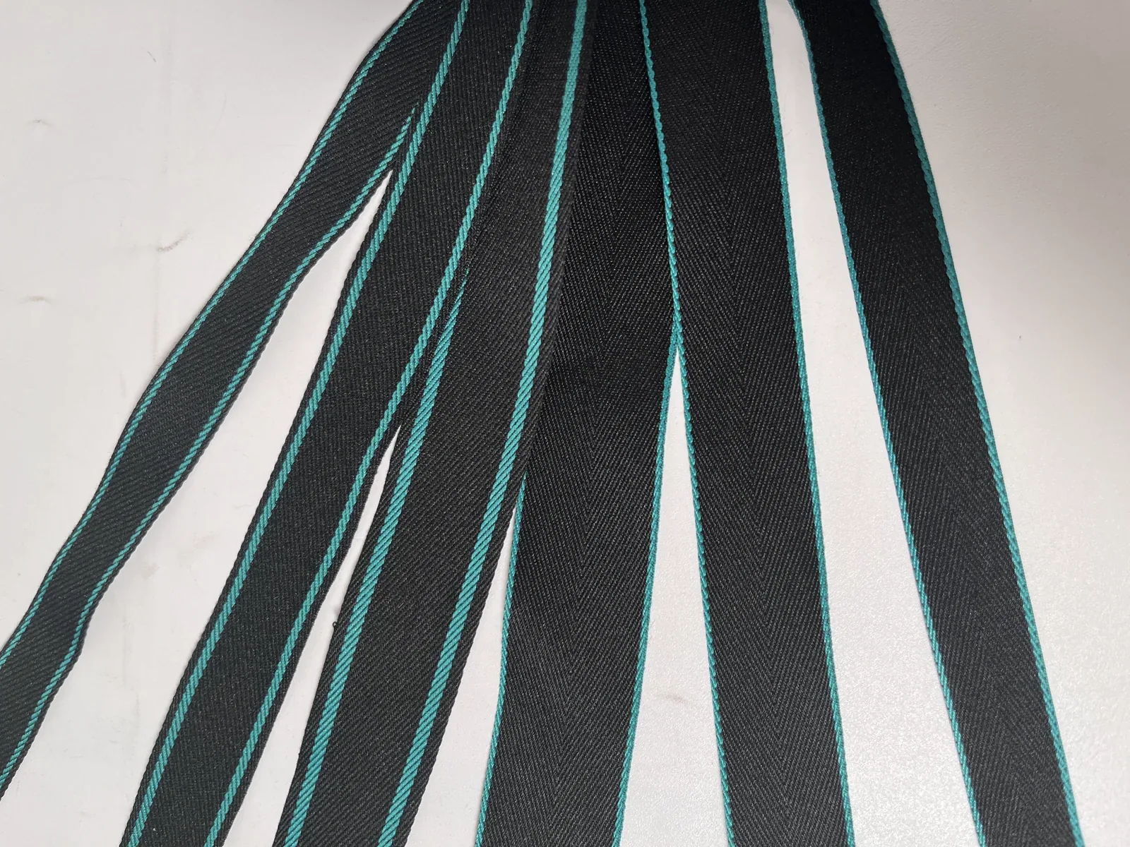 Lengths of black tape with turquoise edge stripes laid side by side